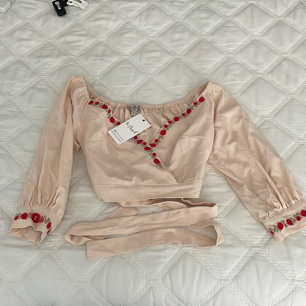 Cute cream wrap-a-round top with roses and never worn because it was too big